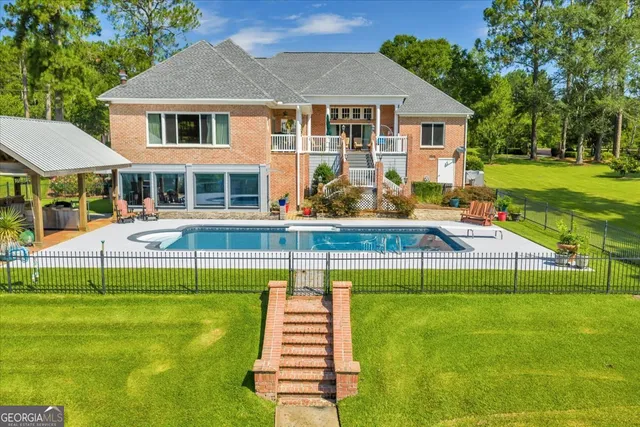 a large white kitchen with granite countertop a large counter top stainless steel appliances and cabinets
