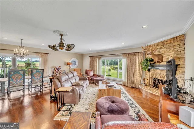 a living room with furniture chandelier and a large window