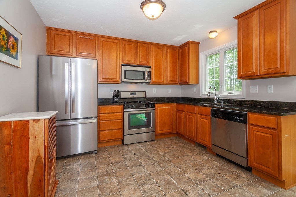 41 Boston Road, Unit 494 Billerica, MA 01862 - Photo 4 of 22 a kitchen with stainless steel appliances granite countertop a stove a sink dishwasher a refrigerator and a microwave oven