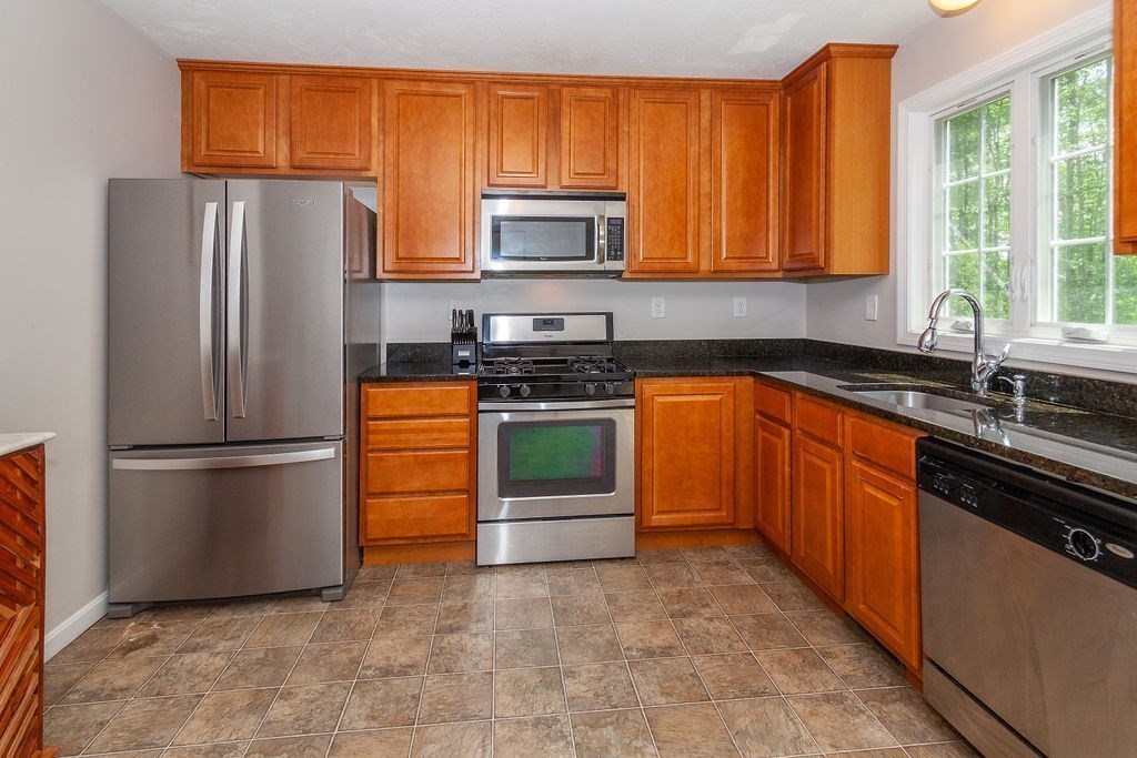 41 Boston Road, Unit 494 Billerica, MA 01862 - Photo 7 of 22 a kitchen with stainless steel appliances granite countertop a refrigerator stove a sink dishwasher and microwave