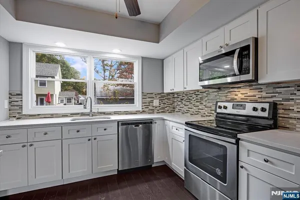 a kitchen with stainless steel appliances granite countertop a stove microwave and cabinets