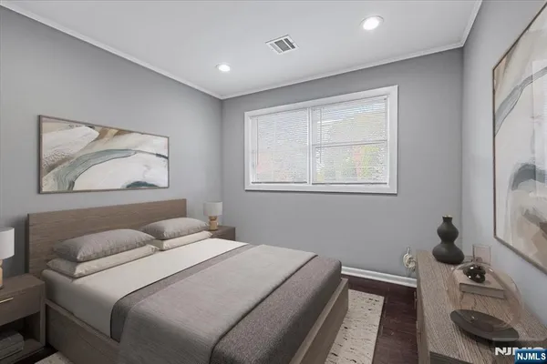 a bedroom with a bed and a painting on the wall