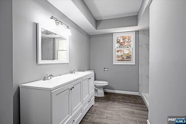 a bathroom with a sink toilet and window