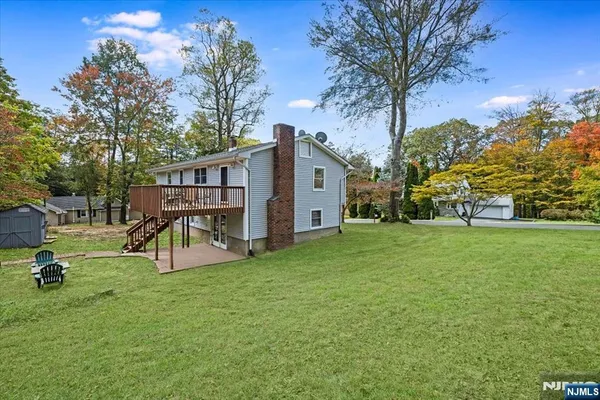 a view of a house with backyard and tree