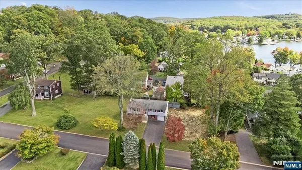 an aerial view of residential houses with outdoor space and trees