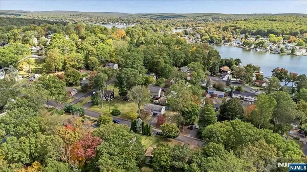 an aerial view of residential houses with outdoor space and trees