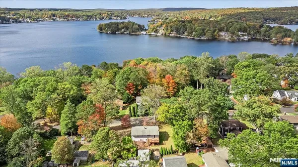 an aerial view of residential houses with outdoor space and river