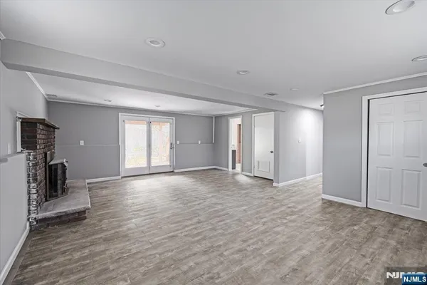 a view of empty room with wooden floor and fireplace