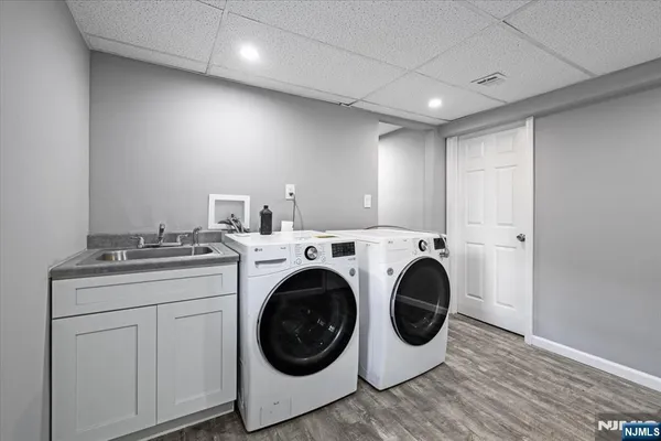 a utility room with dryer washer and empty racks
