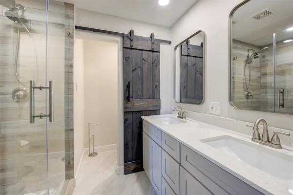 a bathroom with a granite countertop sink mirror and shower
