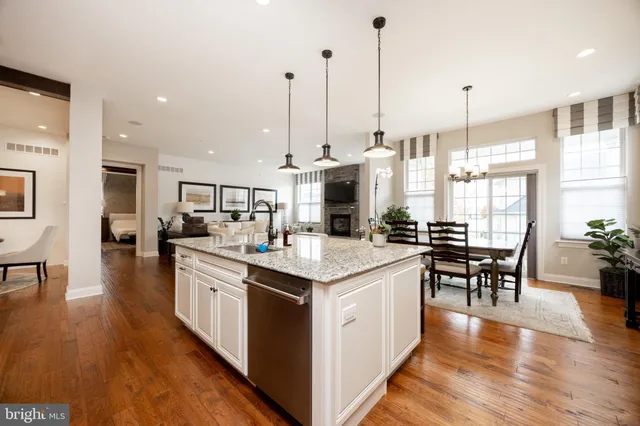 a open kitchen with stainless steel appliances granite countertop a stove and chairs