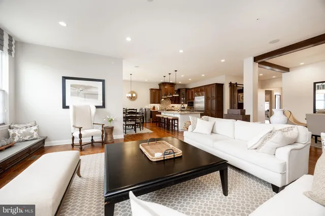 a living room with furniture pool kitchen view and a table