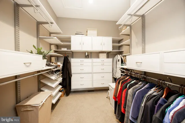 a view of walk in closet with clothes and shoes