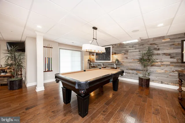 a room with pool table and wooden floor