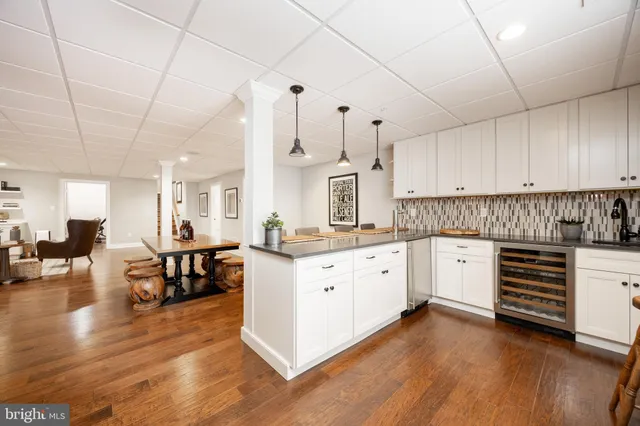 a large white kitchen with lots of counter space a sink appliances and cabinets