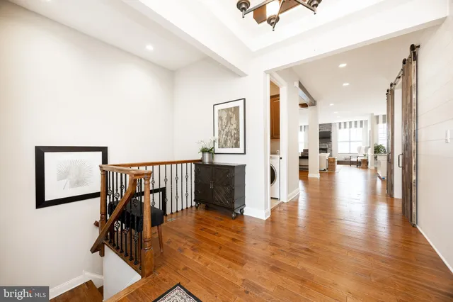 a hallway with wooden floor and windows