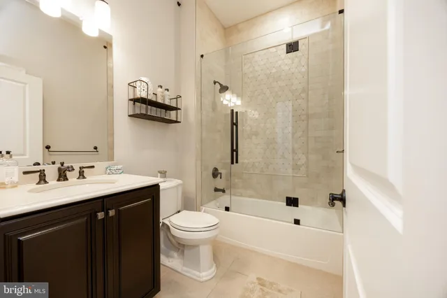 a bathroom with a bathtub shower sink mirror and toilet