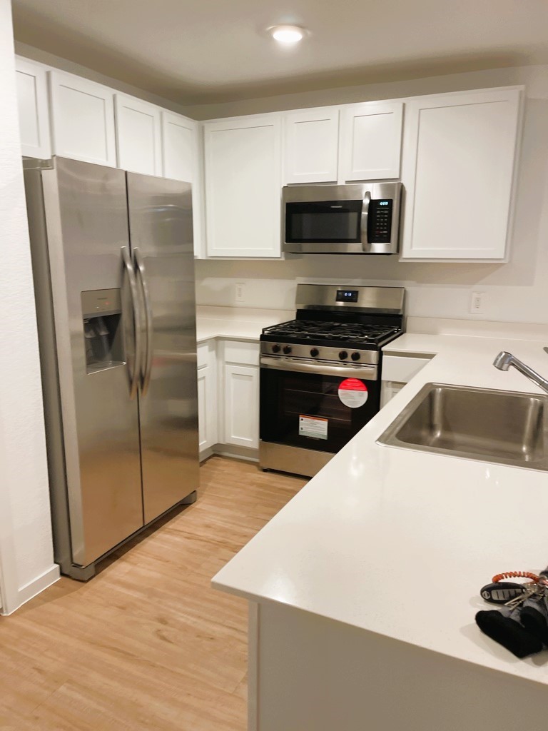 1612 Colina Creek Conroe, TX 77301 - Photo 18 of 33 a kitchen with a refrigerator sink and microwave
