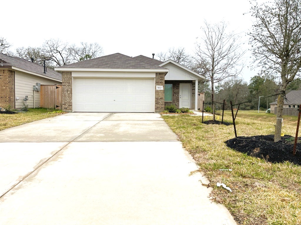 1612 Colina Creek Conroe, TX 77301 - Photo 28 of 33 a front view of a house with a yard and garage
