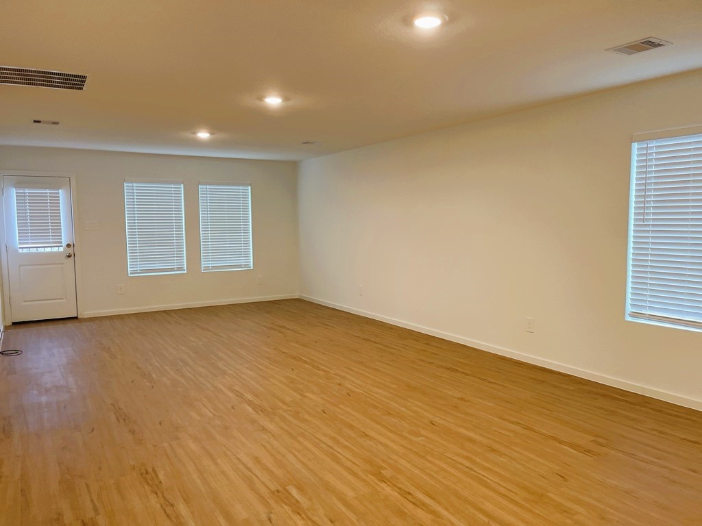 1612 Colina Creek Conroe, TX 77301 - Photo 6 of 33 an empty room with wooden floor and windows