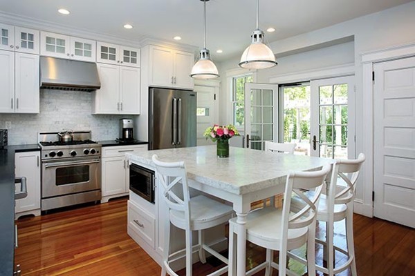 25 Woodside Road Newton, MA 02460 - Photo 4 of 13 a kitchen with stainless steel appliances a dining table chairs stove and sink