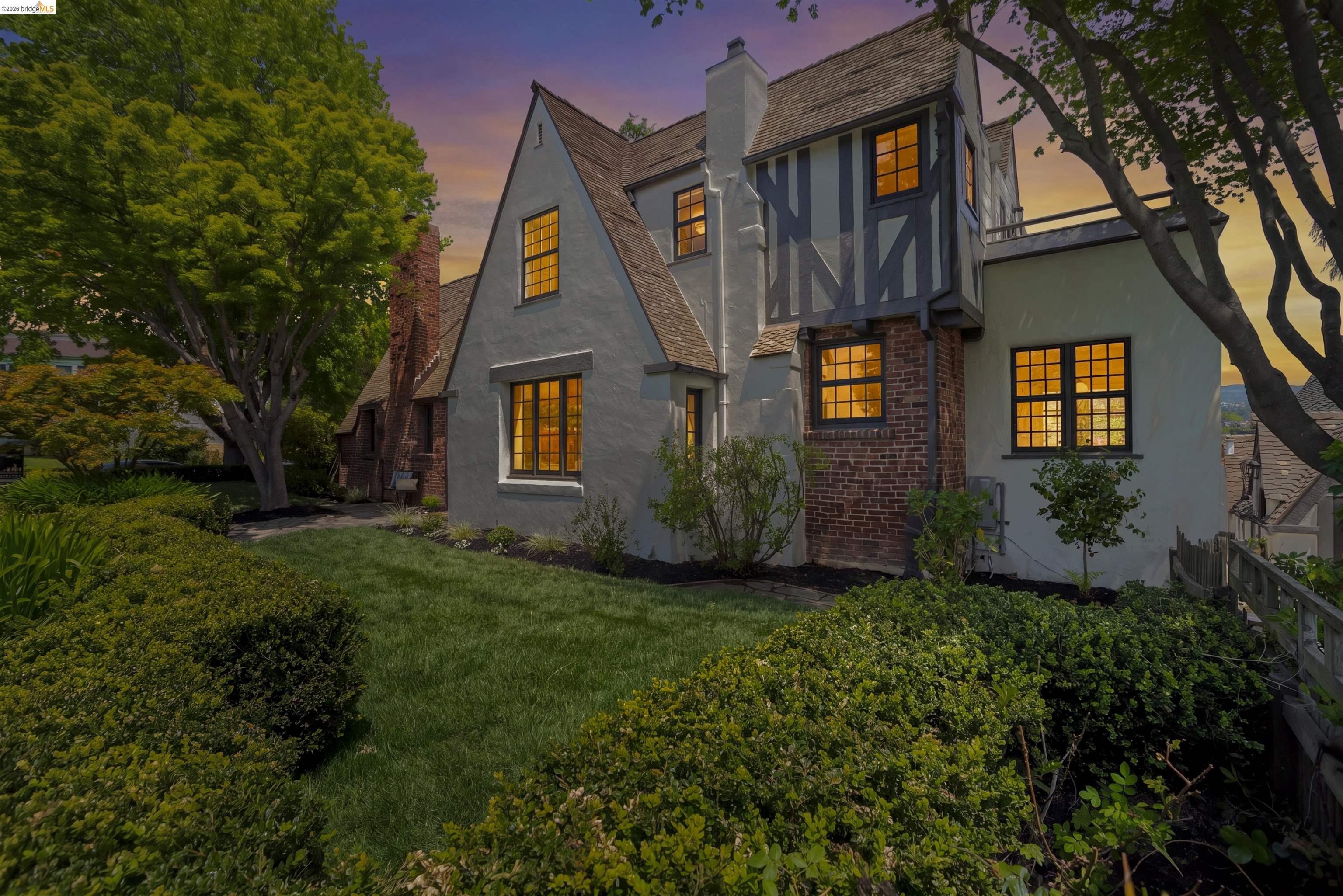 1087 Hubert Road Oakland, CA 94610 - Photo 2 of 67 Tudor-style residence with stucco and brick facade, timber-frame detailing, multi-pane windows, and a sloped roof
