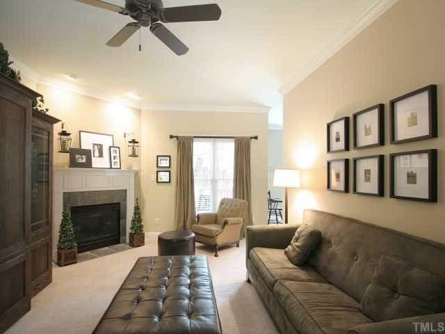 705 Scotts Ridge Trail Apex, NC 27502 - Photo 5 of 12 The heart of the home, this spacious living room has a gas log fireplace with marble tile and raised panel surround. Crown molding and plush carpet. Recessed directional lighting over fireplace. Ceiling fan. Interior of home is newly repainted.