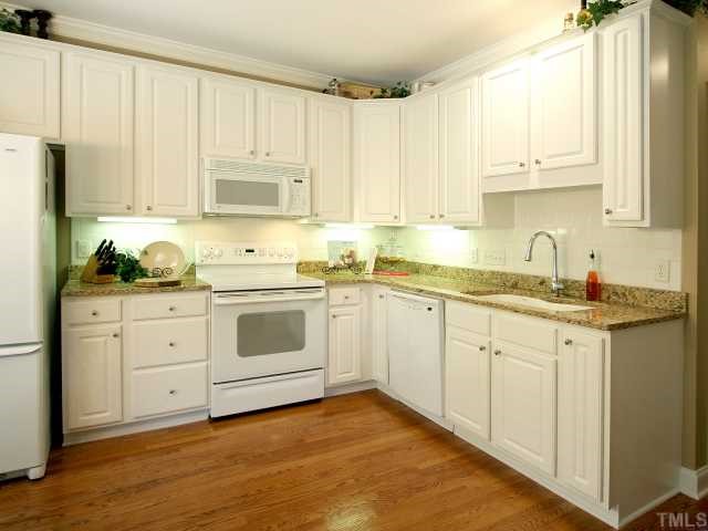 705 Scotts Ridge Trail Apex, NC 27502 - Photo 6 of 12 Lovely kitchen has gleaming hardwood floor. New granite countertops and cast iron sink. New smooth-top electric range. Built-in microwave. New dishwasher. Under-cabinet lighting. Tile backsplash.