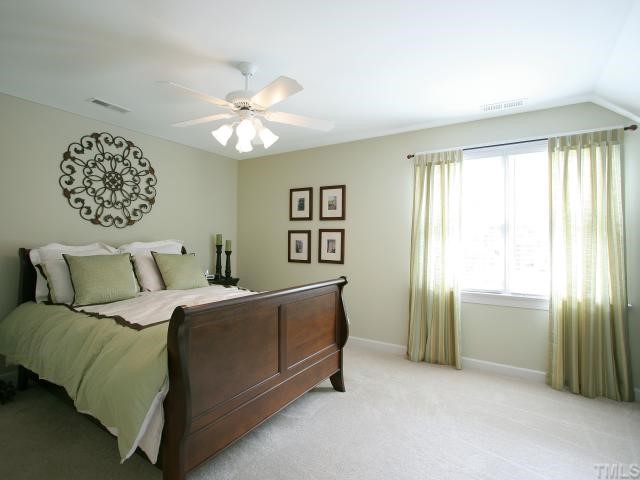 705 Scotts Ridge Trail Apex, NC 27502 - Photo 8 of 12 Spacious master bedroom has plush carpet, ceiling fan with light. Convenient partially finished under-eave storage.