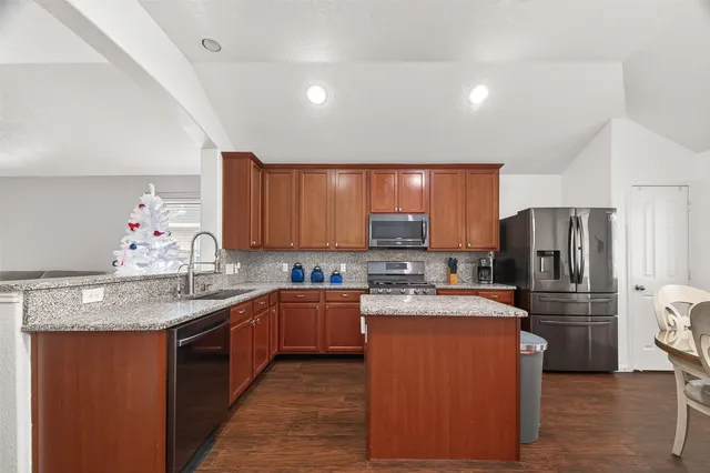 a kitchen with refrigerator a sink a stove a microwave and cabinets