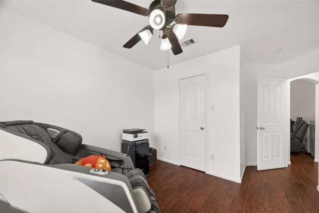 a view of a livingroom with wooden floor and a ceiling fan