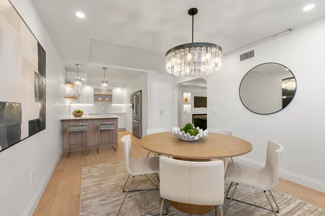 a view of a dining room with furniture a chandelier and wooden floor