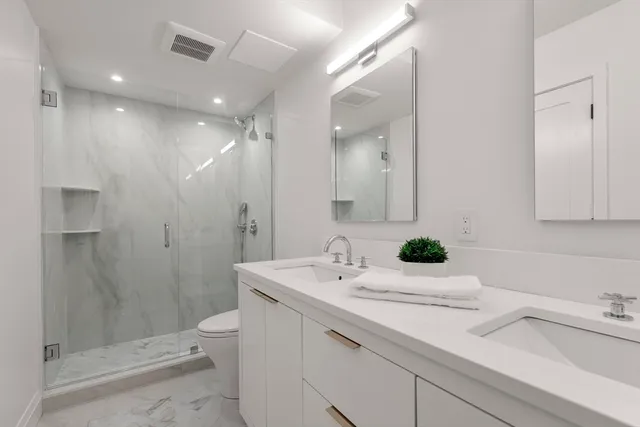 a bathroom with a sink and mirror with toilet