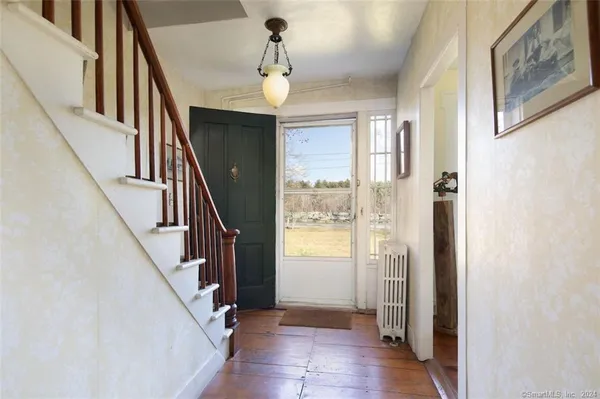a view of an entryway with wooden floor and stairs