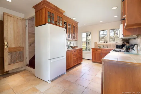 a kitchen with a refrigerator a stove top oven and cabinets