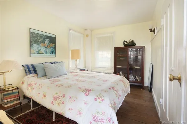 a bedroom with bed and wooden floor