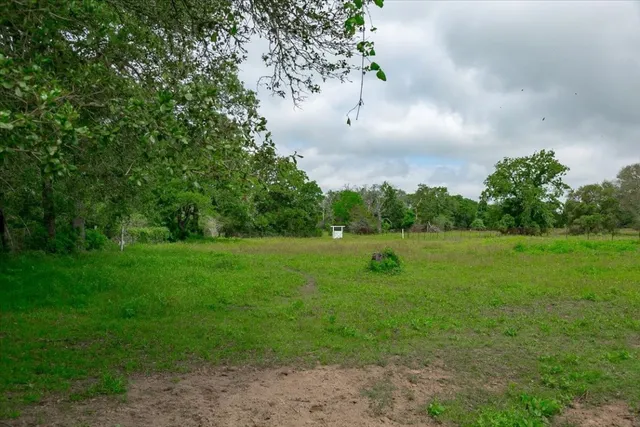 a view of a green field with wooden fence