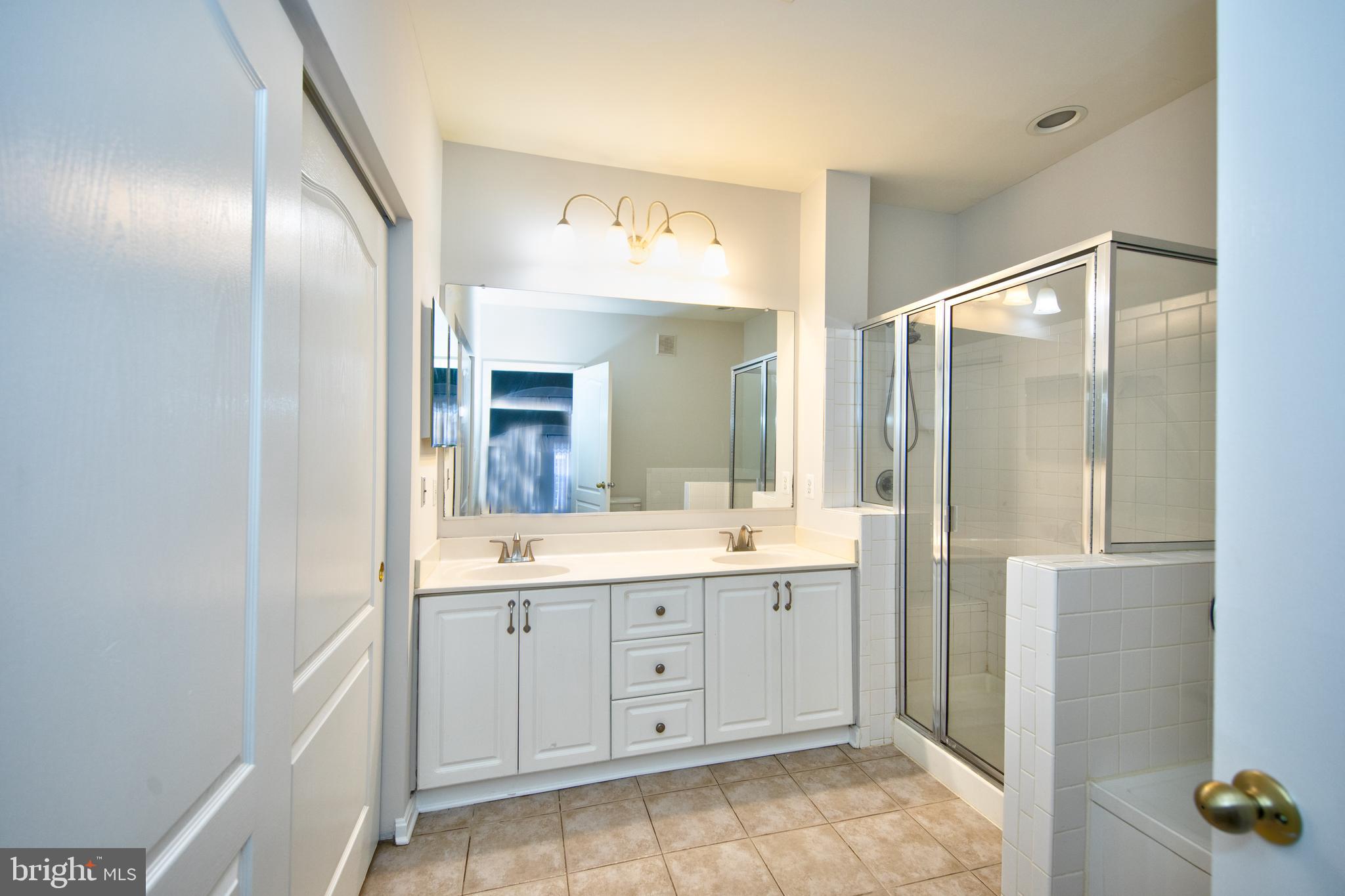400 Symphony Circle, Unit 74B Cockeysville, MD 21030 - Photo 13 of 36 a spacious bathroom with a granite countertop sink a mirror and a