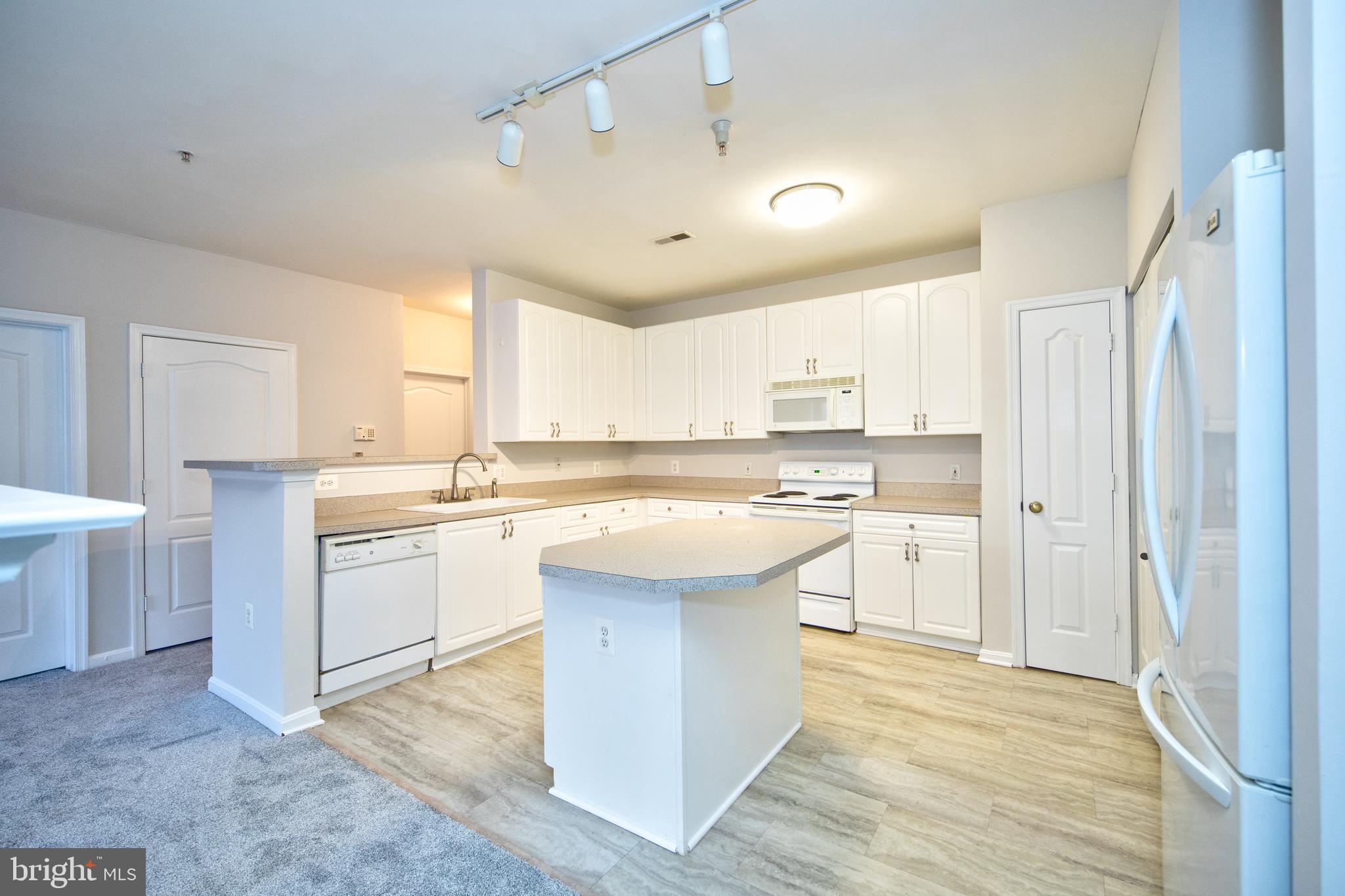 400 Symphony Circle, Unit 74B Cockeysville, MD 21030 - Photo 7 of 36 a kitchen with a sink stove and white cabinets