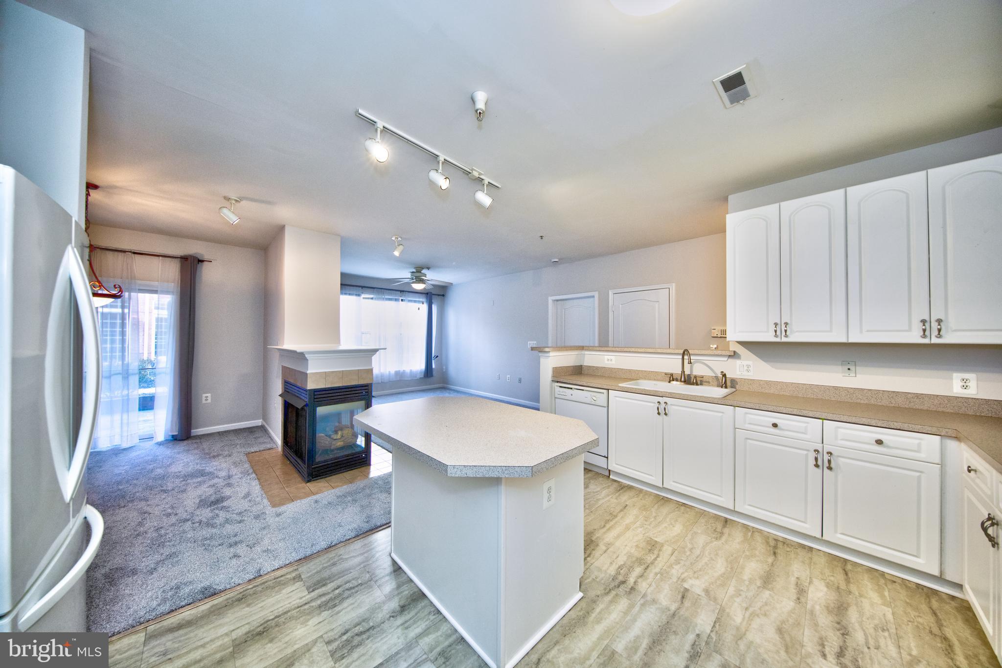 400 Symphony Circle, Unit 74B Cockeysville, MD 21030 - Photo 10 of 36 a large white kitchen with a stove a sink dishwasher and a refrigerator with wooden floor