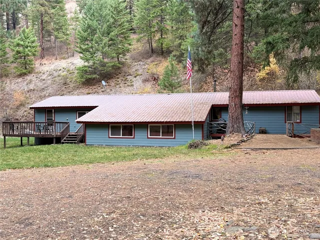 a view of a house with backyard and trees