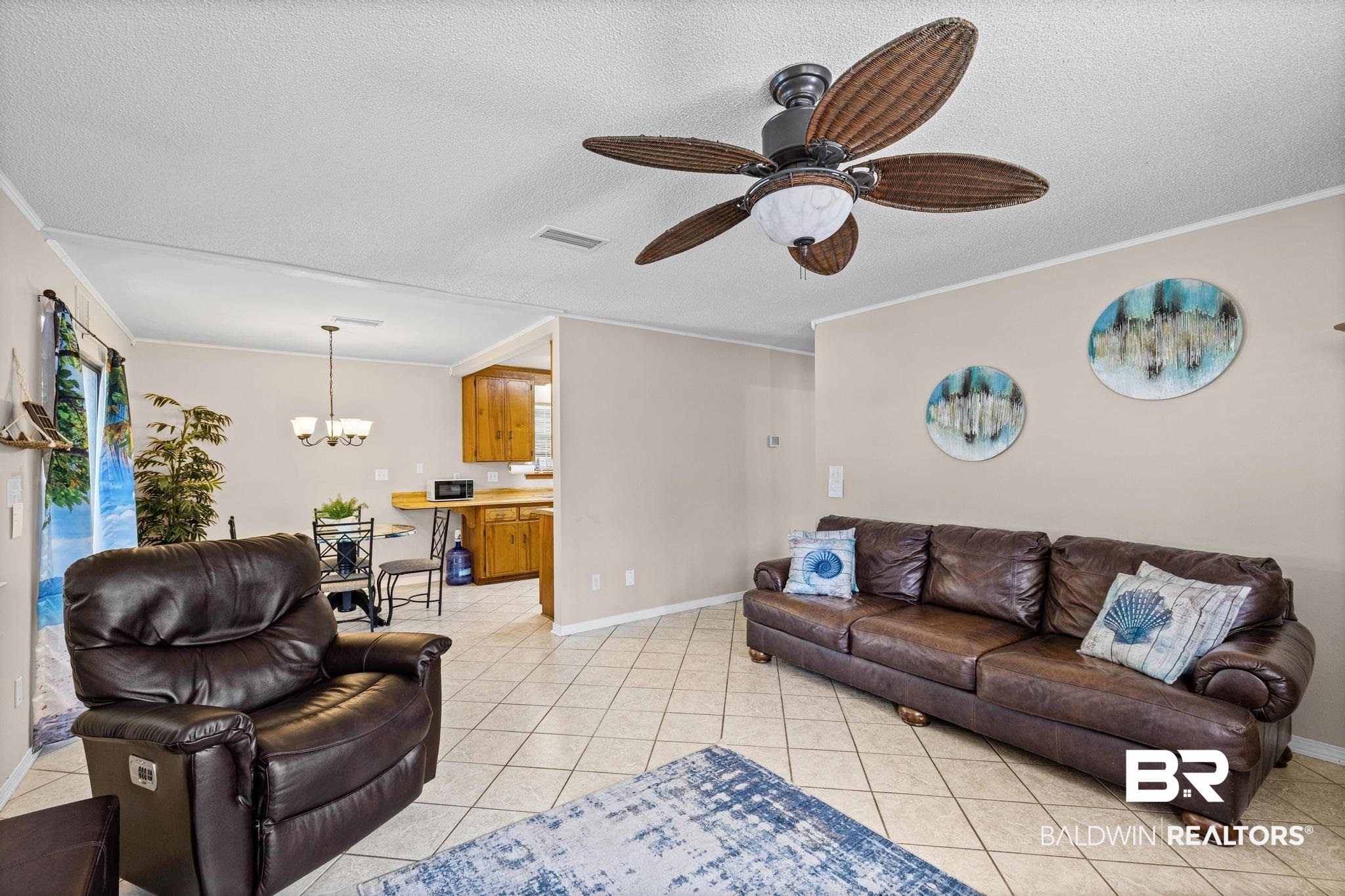 1437 Rio Circle Lillian, AL 36549 - Photo 10 of 46 Living room with a textured ceiling, a chandelier, light tile patterned floors, a ceiling fan, and ornamental molding