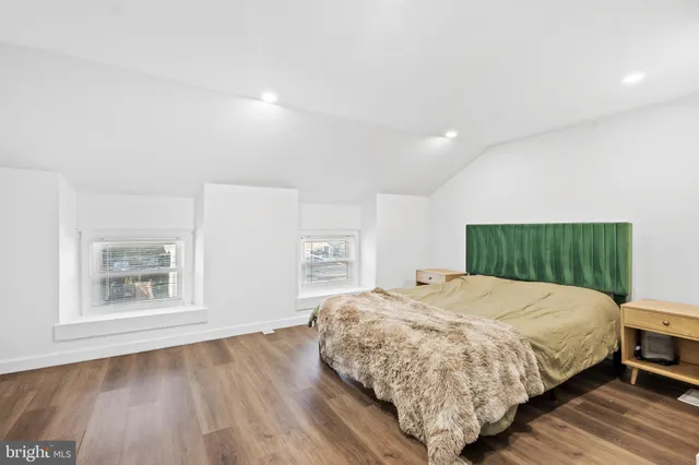 a bedroom with a bed and a painting on the wall