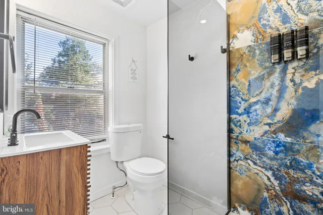 a bathroom with a sink a toilet and shower