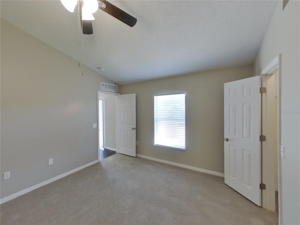 Undisclosed Address Spring Hill, FL 34608 - Photo 11 of 18 an empty room with chandelier fan and windows