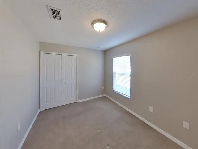 an empty room with windows and closet