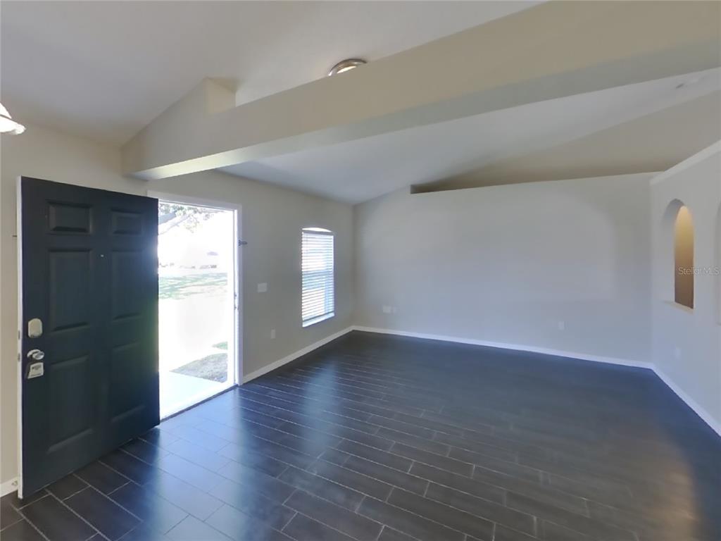 Undisclosed Address Spring Hill, FL 34608 - Photo 5 of 18 an empty room with wooden floor and windows
