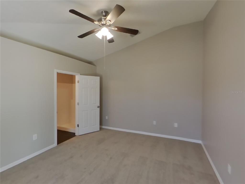 Undisclosed Address Spring Hill, FL 34608 - Photo 9 of 18 an empty room with a ceiling fan and a window