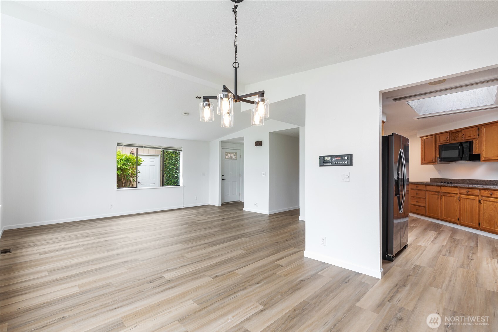 818 243rd Street Southwest Bothell, WA 98021 - Photo 11 of 40 a view of a kitchen and an empty room with wooden floor