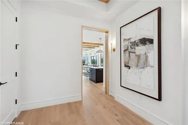 a view of a hallway with wooden floor and a living room